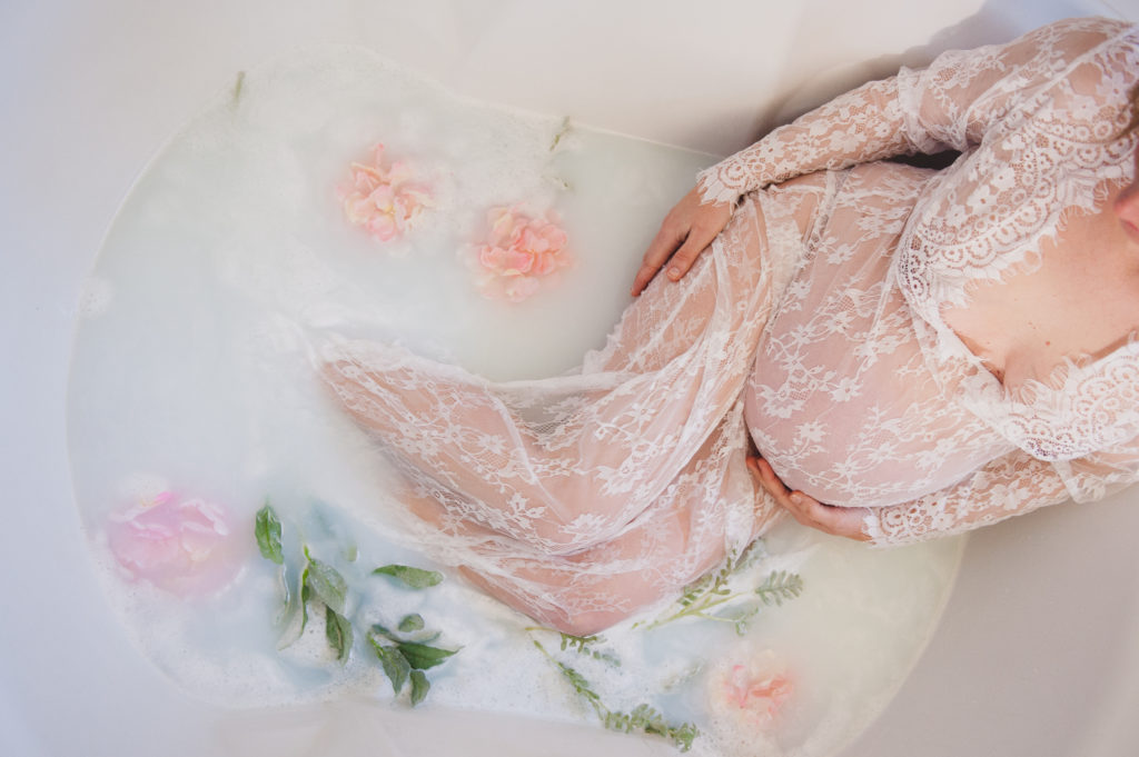 Beautiful milk bath for maternity photos with long lace gown and flowers photographed by Amanda Howse