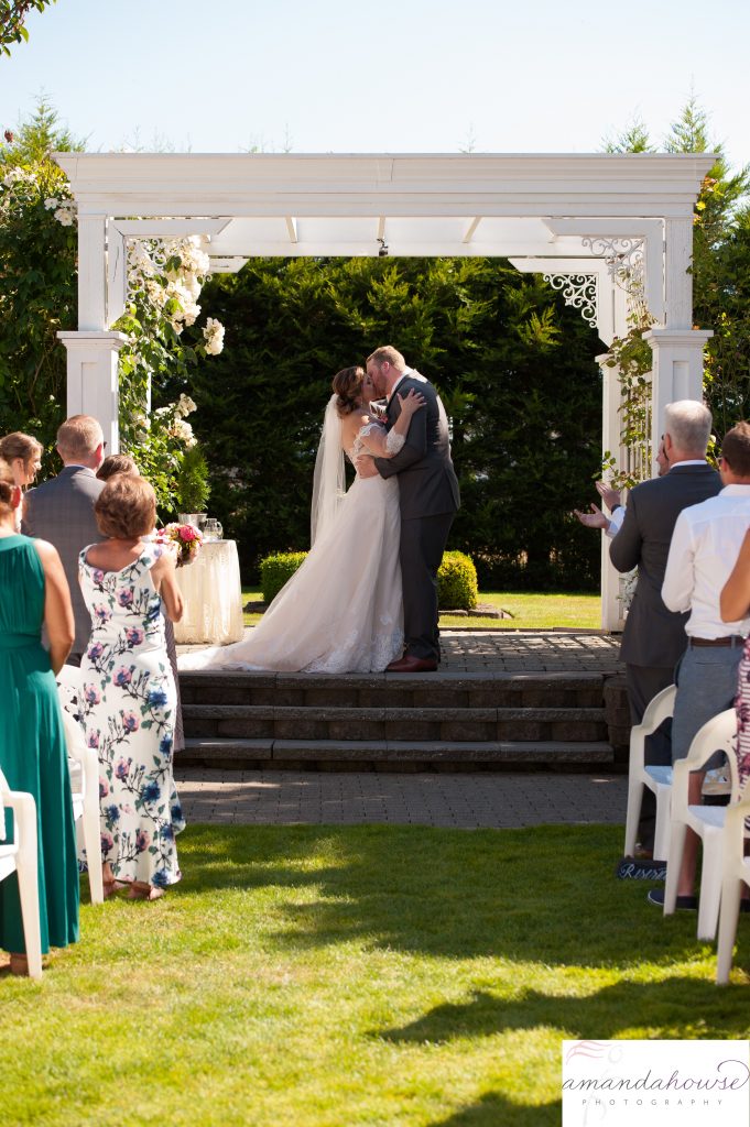 Bride & Groom share First Kiss under Arbor at Genesis Farm and Gardens Photographed by Tacoma Wedding Photographer Amanda Howse
