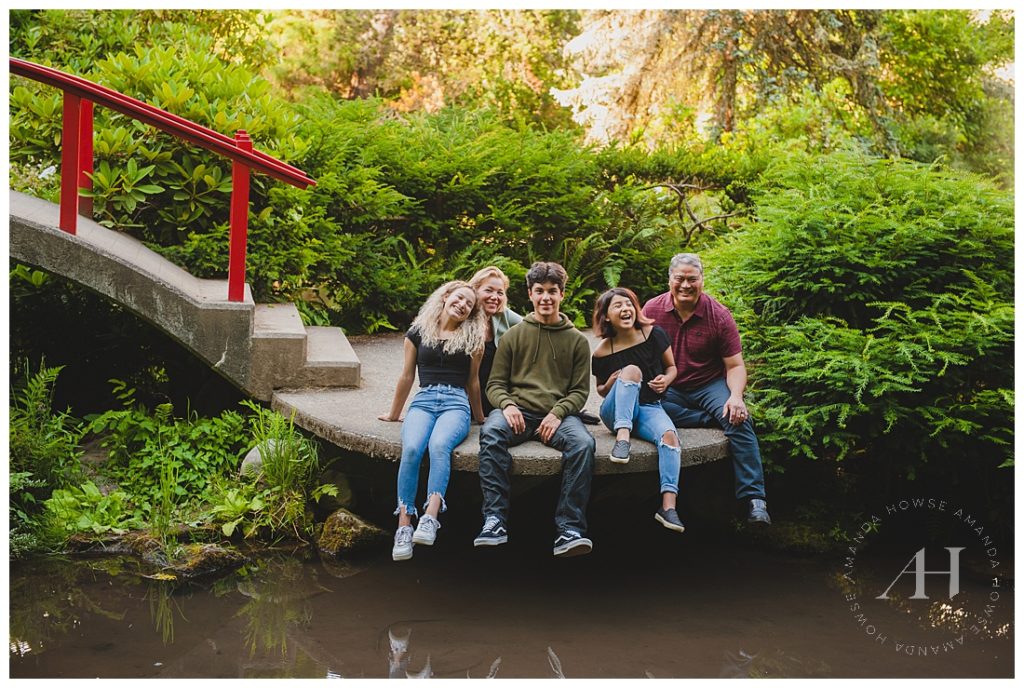 Seattle Family Sitting by a Red Bridge in Kubota Gardens | Photographed by the Best Tacoma Family Photographer Amanda Howse